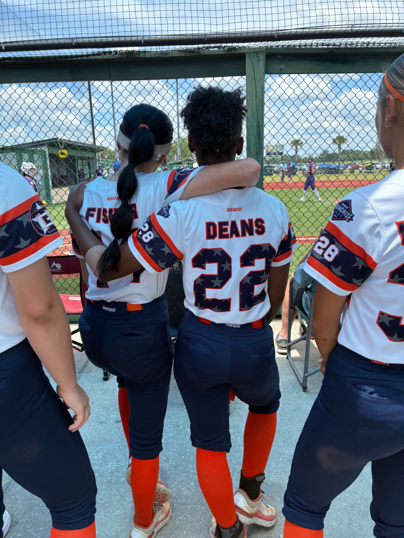 Jade Fisher with teammates in the dugout